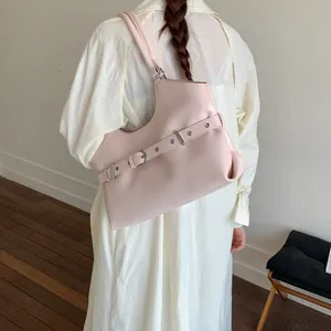 Back view of a woman in a white dress carrying a fashionable pink underarm tote bag