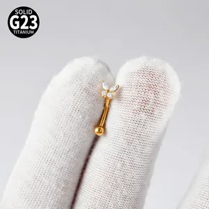 Detailed macro view of gold G23 titanium butterfly zircon curved barbell piercing