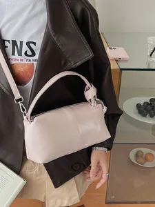 Elegant pink leather pillow bag with a unique knot handle, perfect for a retro chic look.