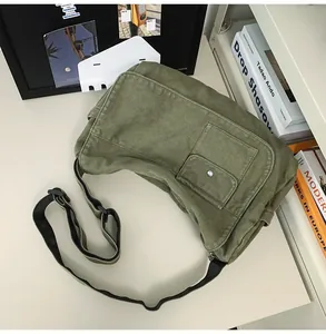 Olive green canvas messenger bag with pocket detailing and adjustable strap