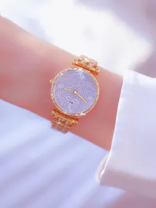 Primer plano de reloj dorado para mujer con esfera llena de brillantes pedrería