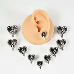 Vista detallada de expansores de oreja de acero en forma de corazón con cremallera