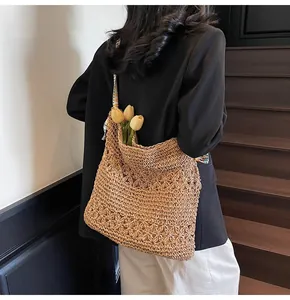 Vue détaillée d'un grand sac cabas en paille avec motif floral et bandoulière