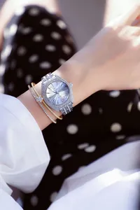 Primer plano de un reloj de lujo con diamantes de imitación en la muñeca de una mujer