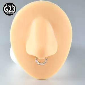 Nahaufnahme eines goldbeschichteten G23-Titan-Septum-Clickers mit Zirkonia im Baguetteschliff