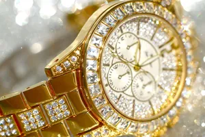 Extreme close-up of a luxury gold women's watch with sparkling crystals and diamonds