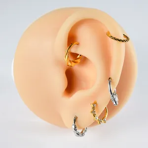Vista dettagliata di vari anelli per piercing in acciaio inossidabile con zirconi su orecchio