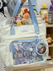 Stylish white canvas ita bag featuring blue straps and a transparent front window display