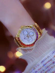 Close-up of a women's gold watch featuring a rainbow crystal bezel and a pavé dial.