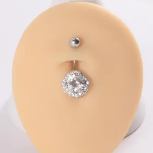 Primer plano de un piercing de ombligo con circonita brillante en un maniquí de piel
