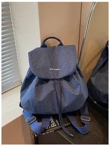 Close-up of a blue checkered casual backpack featuring a drawstring and flap design