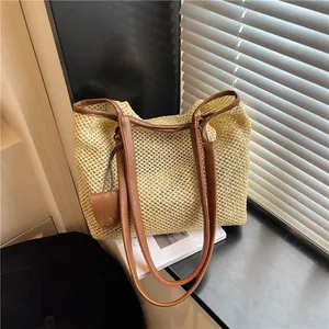 Vista dettagliata della borsa da spiaggia intrecciata beige con spalline in pelle marrone