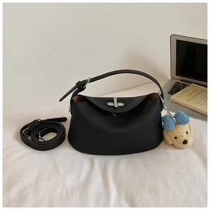 Sophisticated black pebbled leather bucket handbag featuring silver lock and cute plush dog charm