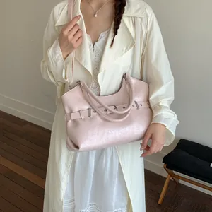 Detailed view of the pink pearl finish tote bag worn by a model in a stylish outfit.