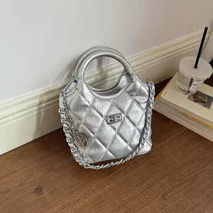 Close-up view of a silver metallic quilted bucket bag with an elegant chain strap