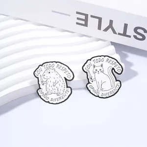 Detail view of cat and capybara enamel pins with Spanish text on white background