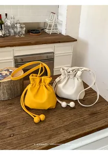 Minimalist candy colored faux leather drawstring bucket bags in vibrant yellow and white