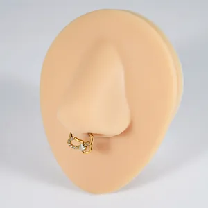 Detail of golden heart-shaped infinity septum ring with white zircon on a nose model