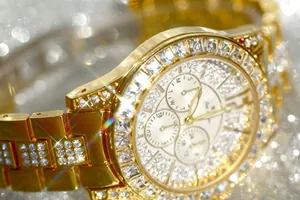 Close-up macro view of luxury gold women's watch with iced-out crystals and multi-function dials