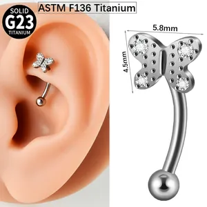 Close-up detail of a G23 titanium butterfly curved barbell piercing with zircon stones.