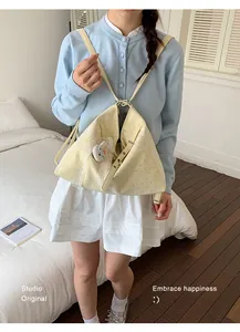Model carrying a stylish pale yellow polka dot bag in a versatile backpack style.