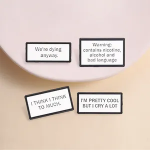 Close-up of rectangular metal pins with humorous and emotional English text phrases.