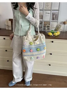 Model carrying a handmade crochet tote bag with colorful flowers and rope handles