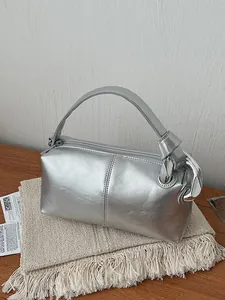 Trendy silver metallic retro pillow handbag with niche designer style and top handle