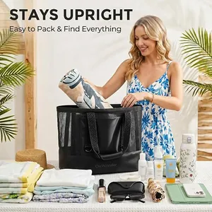 Donna che prepara una grande borsa da spiaggia in rete nera con teli e accessori