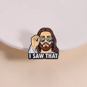 Detail shot of a funny enamel pin featuring Jesus in sunglasses and I SAW THAT text