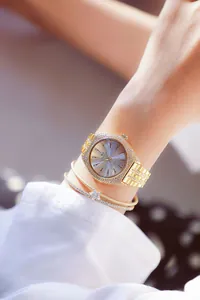 Vista detallada de un lujoso reloj de cuarzo dorado para mujer adornado con diamantes