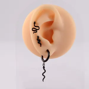 Macro detail of black stainless steel snake earrings shown on a realistic silicone ear model
