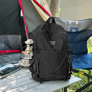 Détail d'un sac à dos de camping noir léger dans un décor de camping rustique en plein air