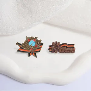 Detailed view of vintage Soviet-style metal badges with St. George ribbon and Russian text.