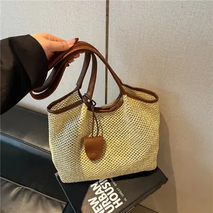 Borsa tote in paglia intrecciata con finiture in pelle marrone per vacanze estive al mare