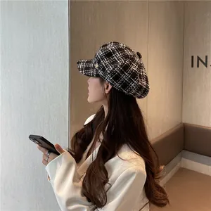 Side view of a woman wearing a black and white plaid newsboy cap in a cozy setting