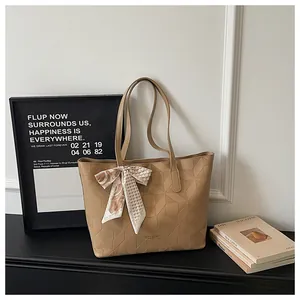 Khaki geometric quilted tote bag with decorative scarf in an office setting