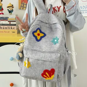 Cute grey heathered school backpack for girls with colorful floral patches and plush bear charm