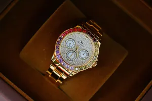 Detailed view of luxury gold ladies watch featuring rainbow bezel and crystal dial