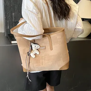Detailansicht einer großen braunen Stofftasche mit Lederriemen und einem kleinen Pferdeanhänger