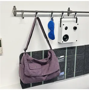 Casual purple canvas messenger bag hanging in a modern and minimalist lifestyle setting