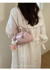 Détail de sac bowling en cuir verni rose, élégant sac bandoulière pour femme au quotidien.
