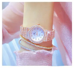 Primer plano de un reloj de oro rosa con diamantes de imitación y pulseras a juego.