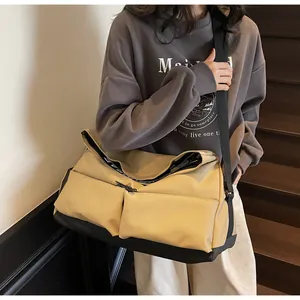 Large beige multi-pocket crossbody sports bag for travel and gym shown in lifestyle use