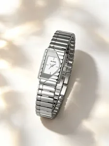Primer plano de un elegante reloj rectangular plateado con un diseño de caja geométrica única.