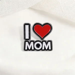 Vista detallada del pin esmaltado 'I Love Mom' con corazón rojo sobre fondo blanco