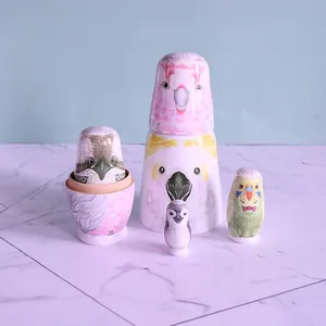 Hand-painted wooden bird nesting dolls set featuring cockatoo and owl illustrations