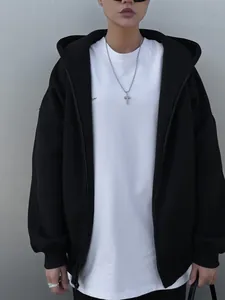 Detailed view of women's oversized black zip-up hoodie over a white t-shirt outfit
