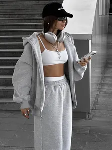Detailed view of women's grey oversized hooded sweatshirt and jogger set in urban setting