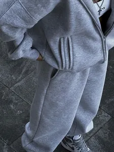 Detailed view of gray two-piece tracksuit featuring a zip-up hoodie and cozy sweatpants